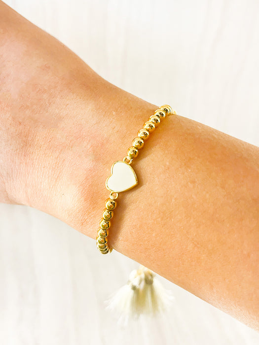 Pulsera de balines con dije de corazón blanco y borla